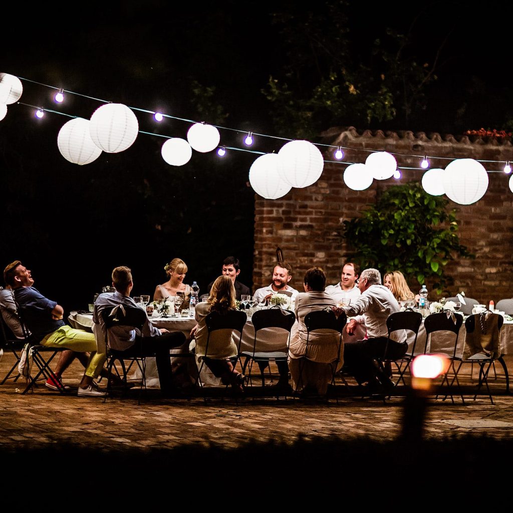 Abendliche Hochzeitsfeier in der Lombardei mit Lichterketten und festlicher Tafel im Freien, fotografiert von Hochzeitsfotograf
